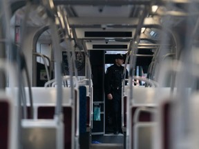 A police officer stands inside a TTC streetcar on Spadina Ave. in Toronto.