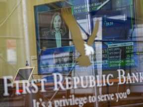 FILE - A television screen displaying financial news, including the stock price of First Republic Bank, is seen inside one of the bank's branches in New York's Financial District, on March 16, 2023. Customers of the bank pulled more than $100 billion in deposits out of the bank during the March crisis, as fears swirled that it could be the third bank to fail after the collapse of Silicon Valley Bank and Signature Bank.