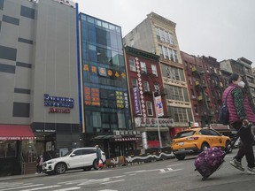 A six story glass facade building, second from left, is believed to be the site of a foreign police outpost for China in New York's Chinatown, Monday April 17, 2023. Justice Department officials say two men have been arrested on charges that they helped establish a secret police outpost in New York City on behalf of the Chinese government.