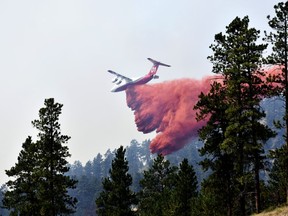 FILE - An aircraft drops fire retardant to slow the spread of the Richard Spring fire, east of Lame Deer, Mont., on Aug. 11, 2021. A legal dispute in Montana could drastically curb the government's use of aerial fire retardant to combat wildfires. Environmentalists have sued the U.S. Forest Service over waterways being polluted with the potentially toxic red slurry that's dropped from aircraft. Forest Service officials have acknowledged more than 200 cases of retardant landing in water.