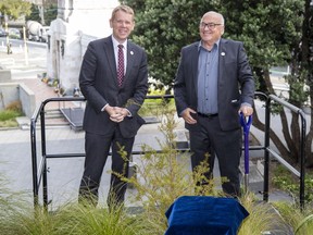 New Zealand Prime Minister Chris Hipkins, left, and and Project Crimson chairman Joris De Bres pose after planting a totara tree in Wellington, Wednesday, April 26, 2023, to mark the upcoming coronation of Britain's King Charles III.
