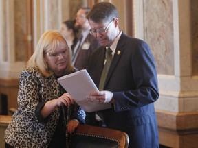 Kansas state Reps. Susan Concannon, left, R-Beloit, and Fred Patton, right, R-Topeka, confer during a session of the House, Thursday, April 6, 2023, at the Statehouse in Topeka, Kan. Both Concannon and Patton supported a bill approved by lawmakers that would require abortion providers to tell patients that medication abortions can be "reversed" once they are started, something experts dispute.