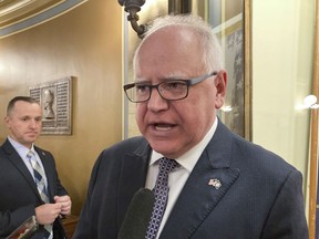 Democratic Minnesota Gov. Tim Walz speaks to reporters after addressing a rally in support of creating a paid family and medical leave system, in the State Capitol on Tuesday, March 21, 2023, in St. Paul, Minn.