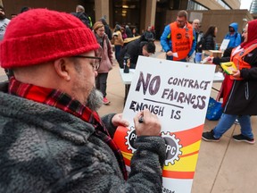 Government workers prepare picket signs outside the federal government Harry Hays Building in downtown Calgary after 155,000 Public Service of Canada workers went on strike on Wednesday, April 19, 2023.