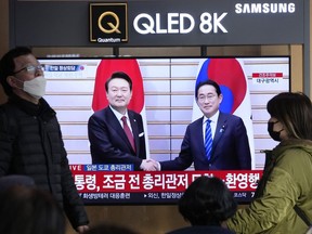 FILE - People pass by a TV screen showing South Korean President Yoon Suk Yeol, left, meeting with Japanese Prime Minister Fumio Kishida in Japan, during a news program at the Seoul Railway Station in Seoul, South Korea, March 16, 2023. Japan's trade ministry on Friday, April 28, 2023, said it has begun procedures to restore preferential trade status for South Korea, days after Seoul took a similar step for Tokyo and requested reciprocity, and more than three years after the countries downgraded each other during a bitter historical dispute.