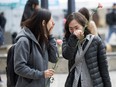 Two women bring flowers as people gather in Toronto's Mel Lastman Square on Tuesday, April 23, 2019 to commemorate a van attack which left 10 people dead. An event commemorating the anniversary of Toronto's attack will be held in the north-end community where the deadly attack took place five years ago today.