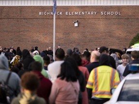 FILE - Students and police gather outside of Richneck Elementary School after a shooting, Jan. 6, 2023 in Newport News, Va. A Virginia teacher who was shot and seriously wounded by her 6-year-old student filed a lawsuit Monday, April 3, 2023, seeking $40 million in damages from school officials, accusing them of gross negligence and of ignoring multiple warnings the day of the shooting that the boy was armed and in a "violent mood."