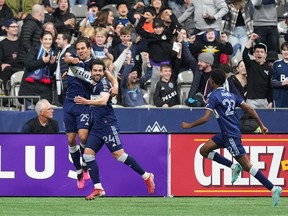 Vancouver Whitecaps' Simon Becher, from left to right, Brian White and Ali Ahmed celebrate White's goal against CF Montreal during the first half of an MLS soccer game in Vancouver, on Saturday, April 1, 2023.