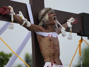 Wilfredo Salvador grimaces after he was nailed to the cross during a reenactment of Jesus Christ's sufferings as part of Good Friday rituals April 7, 2023 in the village of San Pedro, Cutud, Pampanga province, northern Philippines. The real-life crucifixions, a gory Good Friday tradition that is rejected by the Catholic church, resumes in this farming village after a three-year pause due to the coronavirus pandemic.