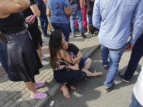 Women sit in an embrace outside the "Cantinho do Bom Pastor" daycare center after a fatal attack on children, in Blumenau, Santa Catarina state, Brazil, Wednesday, April 5, 2023. A man with a hatchet jumped over a wall and invaded the daycare center, killing four children and wounding at least five others, authorities said.
