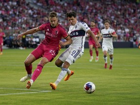 St. Louis City's Lucas Bartlett (24) and Vancouver Whitecaps' Alessandro Schopf (8) battle for the ball during the first half of an MLS soccer match Saturday, May 27, 2023, in St. Louis. The Whitecaps have not won away from B.C. Place in Major League Soccer regular season play this year and have taken 14 of their 17 points at home.