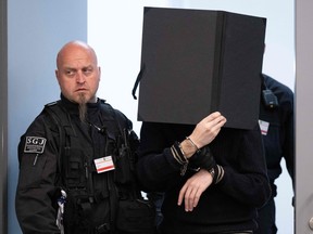 A defendant with his face hidden enters the Higher Regional Court in Dresden, on May 16, 2023, for sentencing.