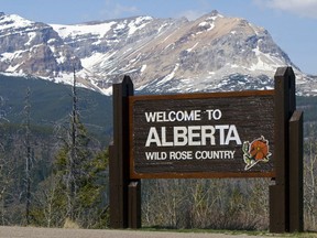 A "Welcome to Alberta" sign with mountains in the background.