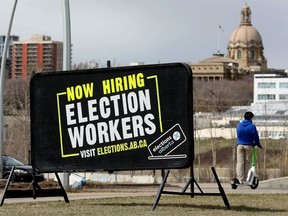 The Alberta Legislature is visible behind a sign in Edmonton's river valley advertising the hiring of election workers ahead of the May 29 provincial vote. Rex Murphy wonders why there hasn't been more discussion of the Trudeau government's "just transition" plans for Alberta during election campaigning.