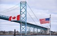 Canadian and American flags fly near the Ambassador Bridge at the Canada-U.S. border crossing in Windsor. (CP Photo)