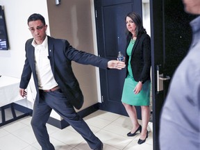 UCP leader Danielle Smith is rushed from an election campaign announcement as protesters disrupt the event in Calgary, May 11, 2023.