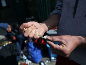 An intravenous (IV) drug user fills a syringe with street drugs in Vancouver's Downtown Eastside on April 6, 2020. REUTERS/Jesse Winter