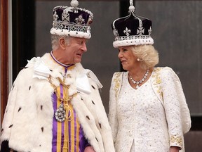King Charles III and Queen Camilla share a moment on the balcony of Buckingham Palace after the Coronation ceremony on May 6, 2023.
