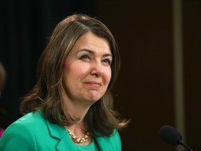 Shoulder level shot of Danielle Smith in a green suit at a speaking event.