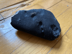 Damage to the floor of a New Jersey home can be seen behind the meteorite that caused it.