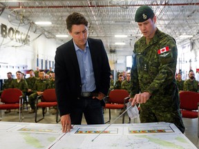 Prime Minister Justin Trudeau is briefed on Alberta wildfires by Canadian Forces Colonel Ben Schmidt at CFB Edmonton, in Sturgeon County, Alberta, May 15, 2023.