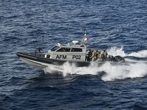 FILE - Members of the Maltese armed forces escort the catamaran carrying Pope Francis and leaving Valletta's harbor for Gozo in Malta Saturday, April 2, 2022. Rescue groups are accusing the European Island nation of Malta of coordinating the return of around 500 people to Libya where they were subsequently imprisoned, in violation of international maritime law.