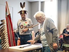 Doreen Lesage, a great-granddaughter of Chief Shingwaukonse and member of Garden River First Nation, stands next to Knowledge Keeper Darrell Boissoneau, as she runs her hand over a pipe that belonged to Chief Shingwaukonse, as the First Nation community bring their historical land claim to Ontario Legislature in Toronto on Thursday, May 18, 2023.