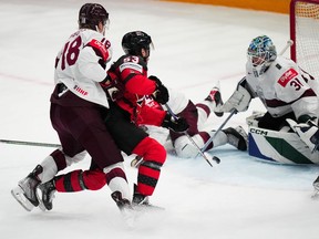 Canada's Michael Carcone (53) shoots against Latvia's goalie Arturs Silovs (31) during their semifinal match at the Ice Hockey World Championship in Tampere, Finland, Saturday, May 27, 2023. Canada won 4-2.