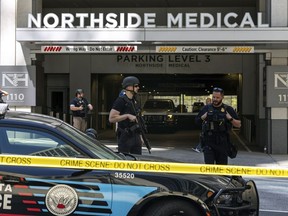 Law enforcement officers stand Northside Hospital Midtown medical office building, where five people were shot, Wednesday, May 3, 2023, in Atlanta. Authorities swarmed the city's bustling midtown neighborhood in search of the 24-year-old suspect.