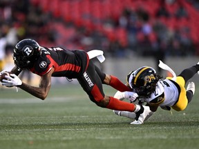 Ottawa Redblacks' Darvin Adams (1) is tackled by Hamilton Tiger-Cats' Tunde Adeleke (2) during first half CFL football action in Ottawa on Saturday, Oct. 29, 2022. A five-foot-10, 208-pound Adeleke is entering his sixth CFL season and fourth with Hamilton.