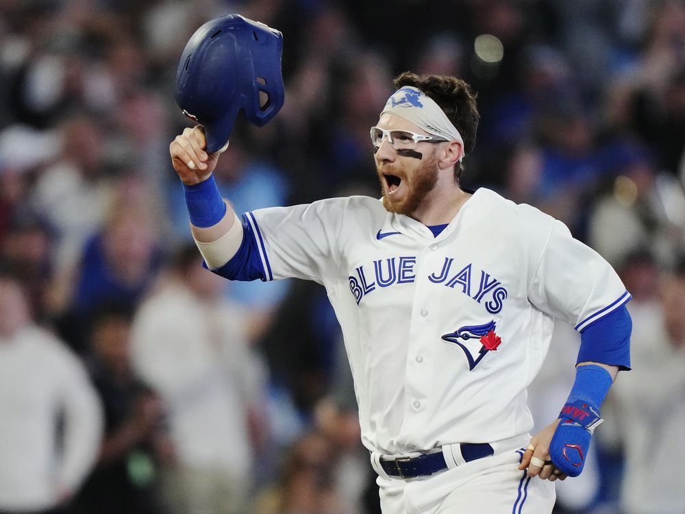 Toronto Blue Jays' Whit Merrifield, left, celebrates with third