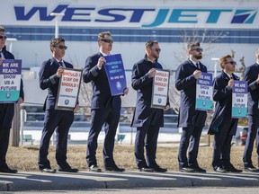 Members of the Air Line Pilots Association demonstrate amid contract negotiations outside the WestJet headquarters in Calgary, Alta., Friday, March 31, 2023.