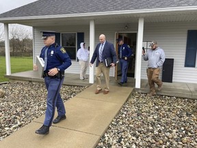 The Michigan State Police exit the Adams Township Hall after executing a search warrant, Oct. 29, 2021 in Hillsdale, Mich. The search warrant was part of an investigation into actions by Clerk Stephanie Scott who has been stripped of her role in future elections. The clerk in one of the Michigan's most conservative counties faces a recall election after the state says she improperly handled voting equipment following false claims about the 2020 election.