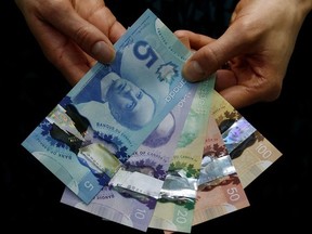 Hands holding Canadian cash