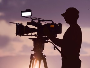 Silhouette of a man filming a movie.