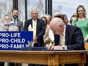 FILE - Montana Gov. Greg Gianforte signs a suite of bills aimed at restricting access to abortion during a bill signing ceremony on the steps of the state Capitol in Helena, Mont., May 3, 2023. Planned Parenthood of Montana filed a complaint on Tuesday, May 16, 2023, to temporarily block a law that bans the abortion method most commonly used after 15 weeks of pregnancy. The court filing happened just hours after Gianforte's office announced he had signed the bill.