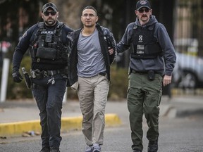 FILE - Solomon Peña, center, a Republican candidate for New Mexico House District 14, is taken into custody by Albuquerque, New Mexico, Police officers, Jan. 16, 2023, in southwest Albuquerque. Peña has been indicted on federal charges including interference with the electoral process in connection with a series of drive-by shootings at the homes of state and local lawmakers in Albuquerque, according to a grand jury indictment that was unsealed Wednesday, May 31.