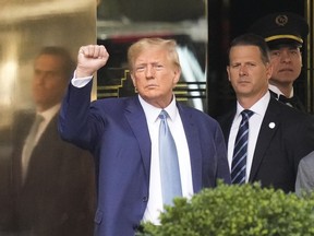 FILE - Former President Donald Trump, left, gestures as he leaves Trump Tower in New York, Thursday, April 13, 2023. The judge in Donald Trump's criminal case is holding a hybrid hearing Tuesday to make doubly sure the former president is aware of new rules barring him from using evidence to attack witnesses. Trump is allowed to speak publicly about the case, but he risks being held in contempt if he uses evidence turned over by prosecutors in the pretrial discovery process to target witnesses or others involved in the case.
