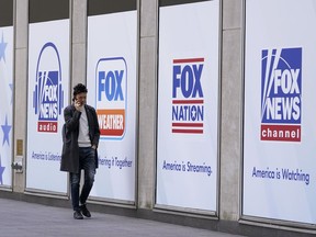 File - A man walks past the News Corp. and Fox News headquarters on Wednesday, April 19, 2023, in New York.