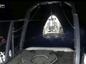 In this frame grab from video broadcast by SpaceX, recovery crews lift and secure the SpaceX Dragon capsule after it splashed down into the Gulf of Mexico, just off the Florida Panhandle, late Tuesday, May 30, 2023. The private flight carrying two Saudi astronauts and other passengers returned to Earth after a nine-day trip to the International Space Station. (SpaceX via AP)
