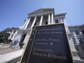 FILE - Visitors stand on the west steps of the Colorado Capitol, April 23, 2023, in Denver. Colorado is tackling a surge in eating disorders with two bills signed Tuesday, May 30. The legislation will create a state program dedicated finding solutions to the mental illness, ban the use of body mass index in determining treatment and restrict the sale of diet pills to minors.