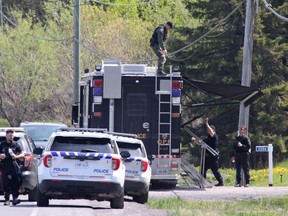 OPP officers set up a mobile support unit near the scene of a shooting where one Ontario Provincial Police officer was killed and two others injured in the town of Bourget, Ont. on Thursday, May 11, 2023.