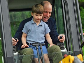 Prince William, Prince of Wales, is helped by his son Prince Louis as he uses an excavator while taking part in the Big Help Out, during a visit to the 3rd Upton Scouts Hut in London, England, on May 8, 2023.