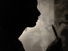 A person poses for a photograph as they vape in Melbourne, March 23, 2023.