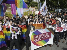 Lawyers of plaintiffs and supporters celebrate following a ruling in front of the Nagoya District Court in Nagoya, central Japan Tuesday, May 30, 2023. The Japanese court on Tuesday found the government policy of not allowing same-sex marriage unconstitutional, a closely-watched ruling that could give a push toward achieving marriage equality in a country that still resists anti-discrimination law for LGBTQ+ rights. A banner, center, reads "unconstitutional judgment." (Kyodo News via AP)