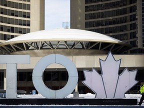 City hall watchers say the first major debate of Toronto's mayoral byelection appeared to set out the battle lines for the campaign's second half. A Toronto city worker walks outside of Toronto City Hall, Saturday, Feb. 29, 2020.
