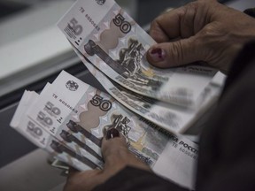Canada's financial intelligence agency is warning that Russians subject to economic sanctions due to Moscow's attack on Ukraine could try to evade them using shell companies, cryptocurrency and real-estate transactions. A pensioner counts Russian rubles in Donetsk, eastern Ukraine, April 1, 2015.