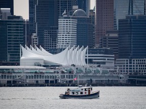 A recreational boat travels on the harbour as Canada Place and the downtown Vancouver skyline are seen from North Vancouver, B.C., Saturday, March 12, 2022. The City of Vancouver says it is giving Canada Place a second, honorary name to acknowledge historical discrimination against South Asian communities.