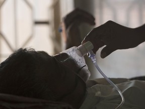 FILE - A relative adjusts the oxygen mask of a tuberculosis patient at a TB hospital on World Tuberculosis Day in Hyderabad, India, March 24, 2018. Top U.N. officials and health industry leaders are trying to tackle an alarming surge in tuberculosis, which is now killing more people worldwide than COVID-19 or AIDS. Among the problems: a high number of cases in conflict zones, including Ukraine and Sudan, where it's difficult to track down people with the disease and diagnose new sufferers.