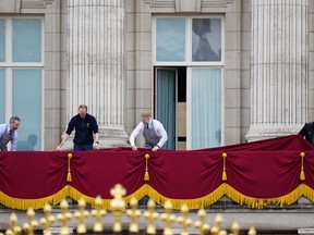 Workers prepare the balcony of Buckingham Palace ahead of Britain's King Charles III coronation ceremony in London, Saturday, May 6, 2023.